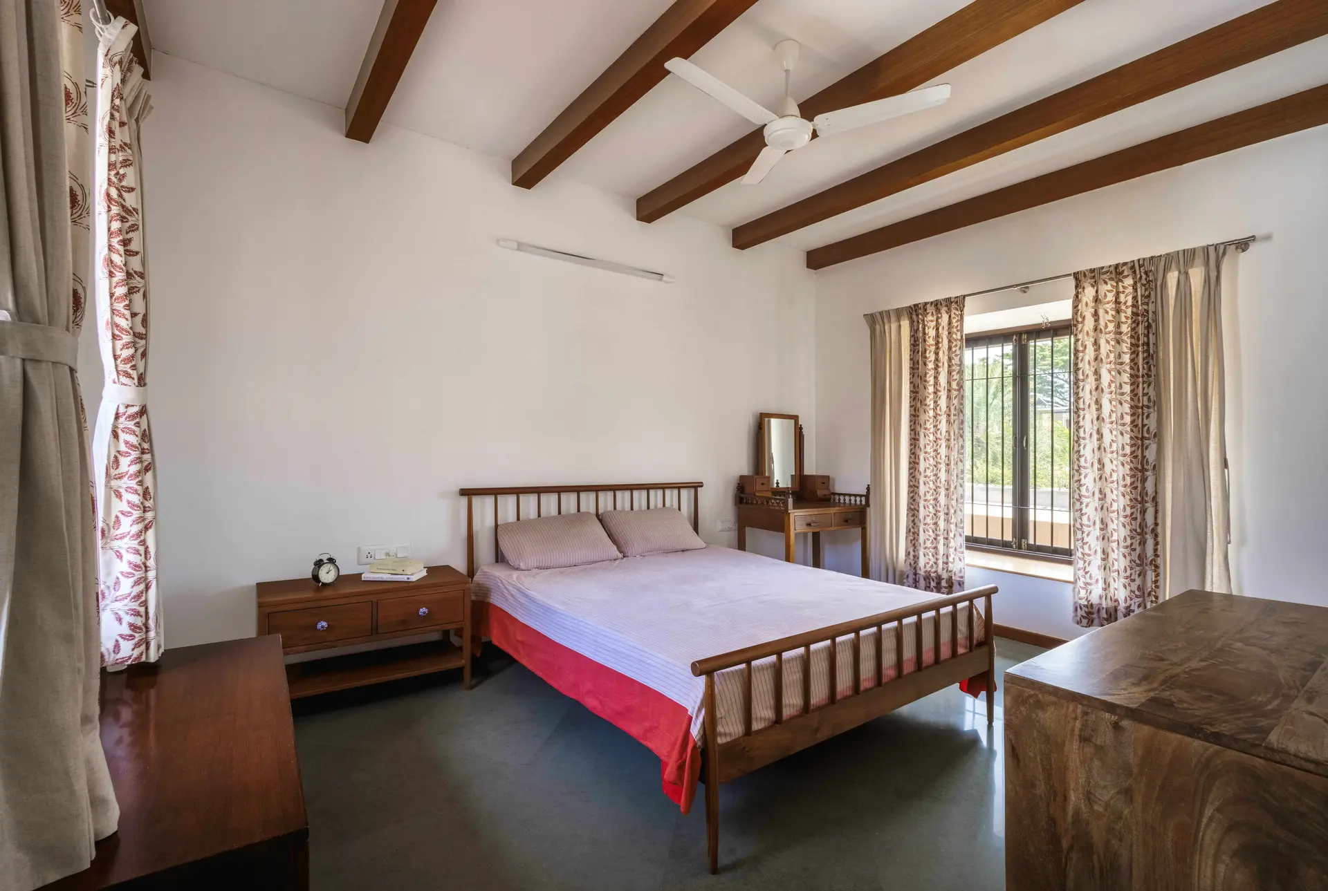 Bedroom with rods headboard side table and wood ceiling beams
